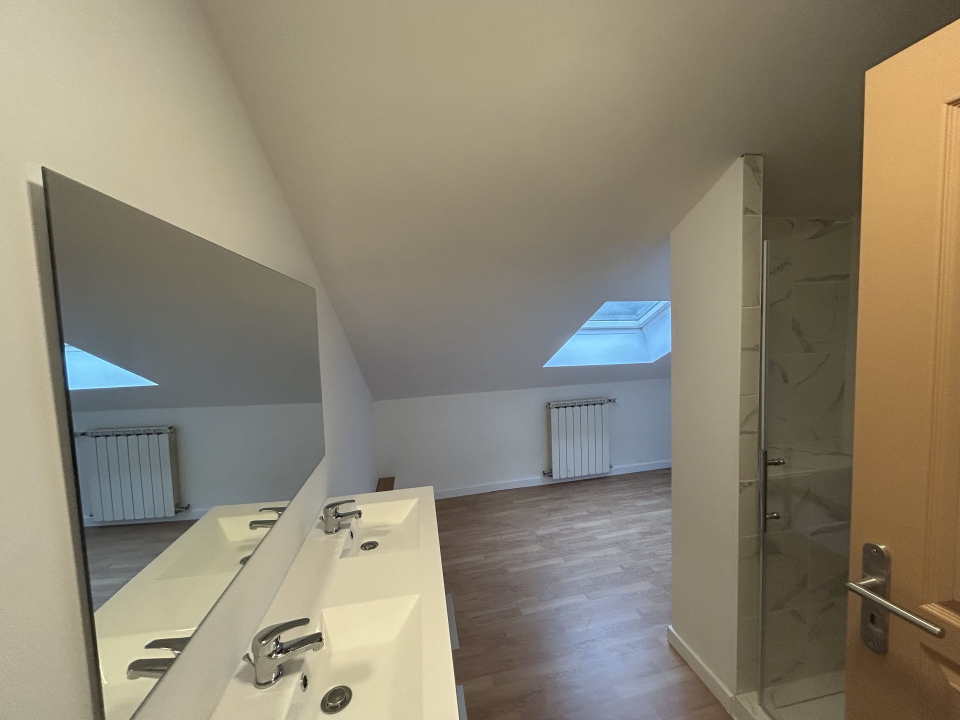 Salle de bain rénovée avec double vasque et parquet contemporain