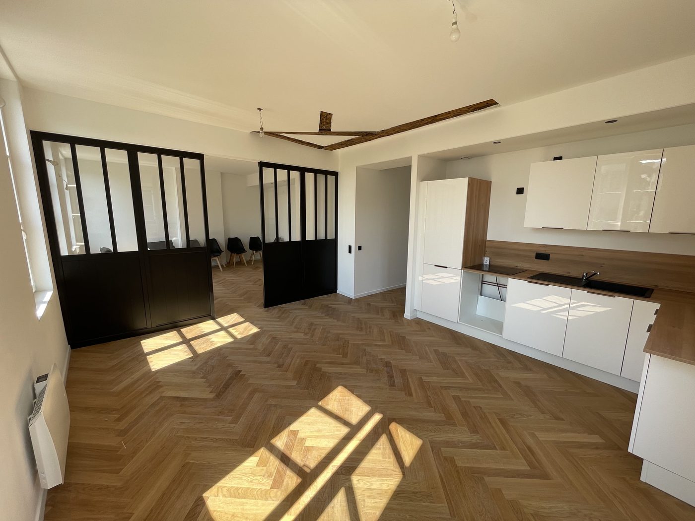 Appartement après rénovation — cuisine neuve, verrière et parquet à chevrons