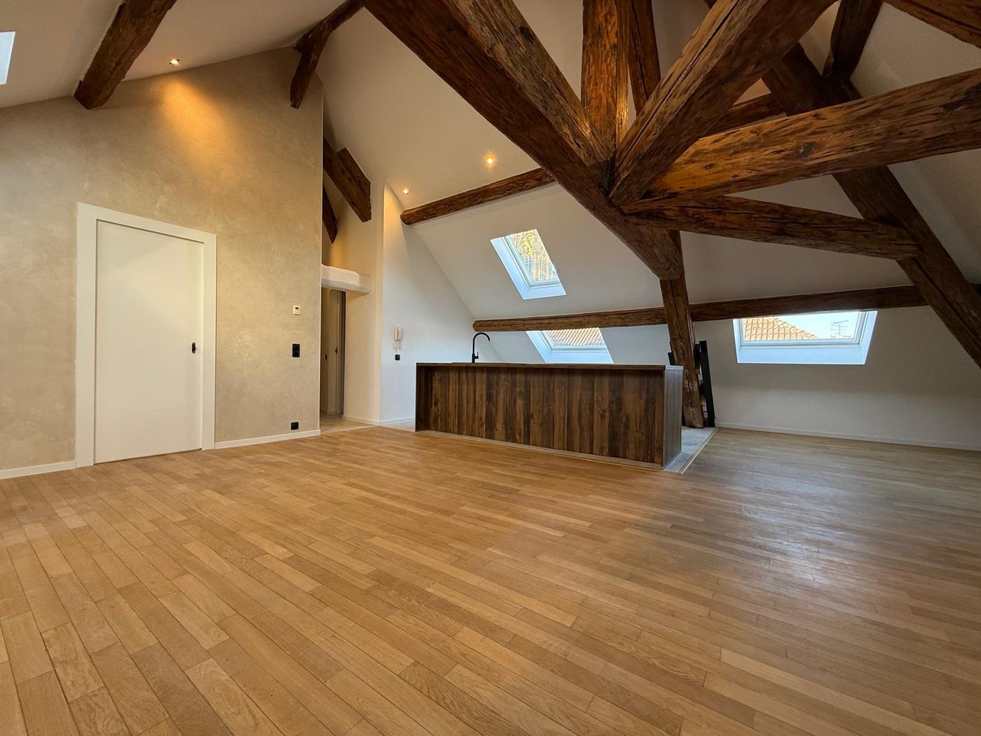 Dernier étage après rénovation — charpente mise en valeur et parquet neuf