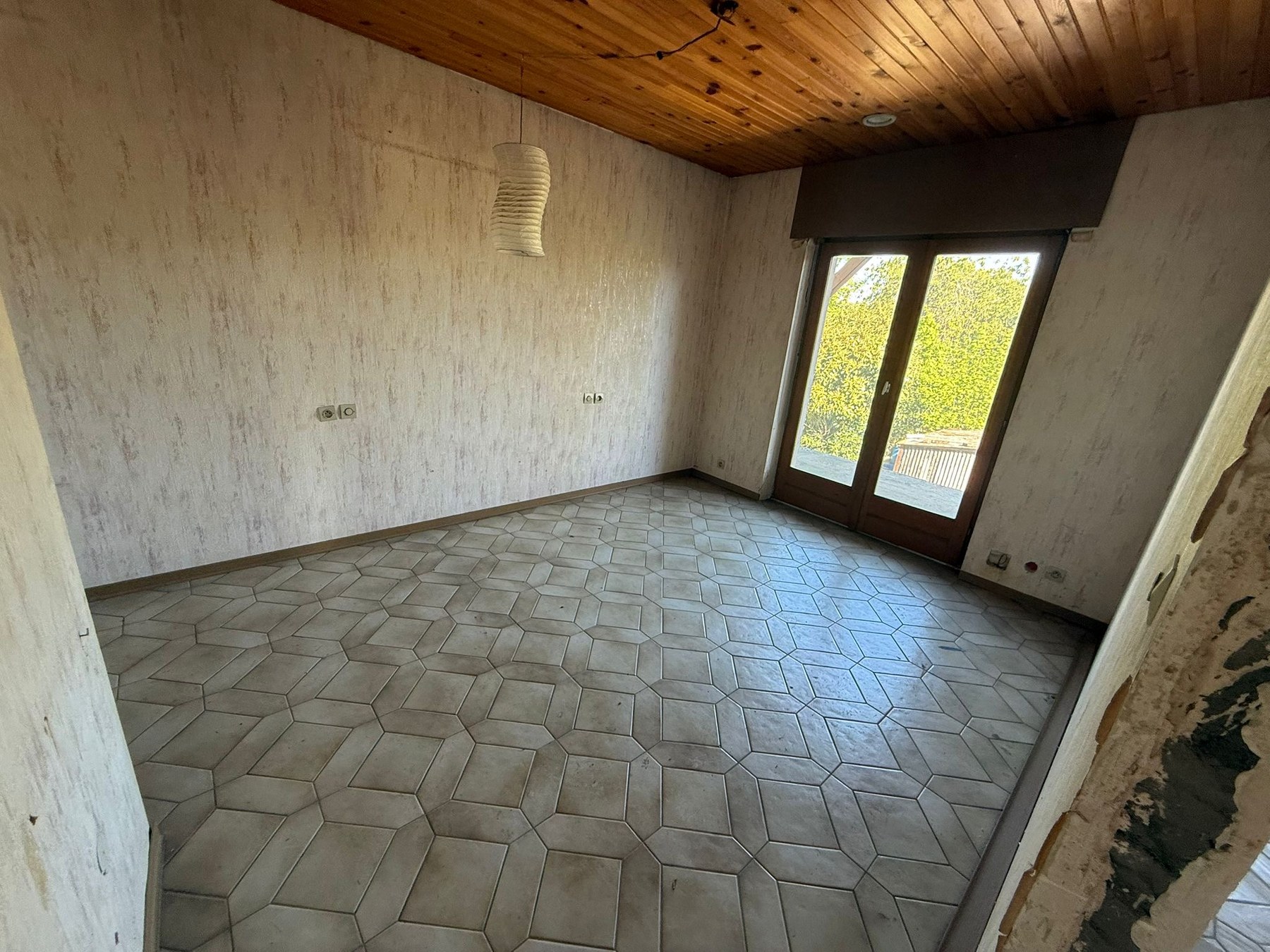 Chambre avec accès jardin, papiers peints et plafond à reprendre