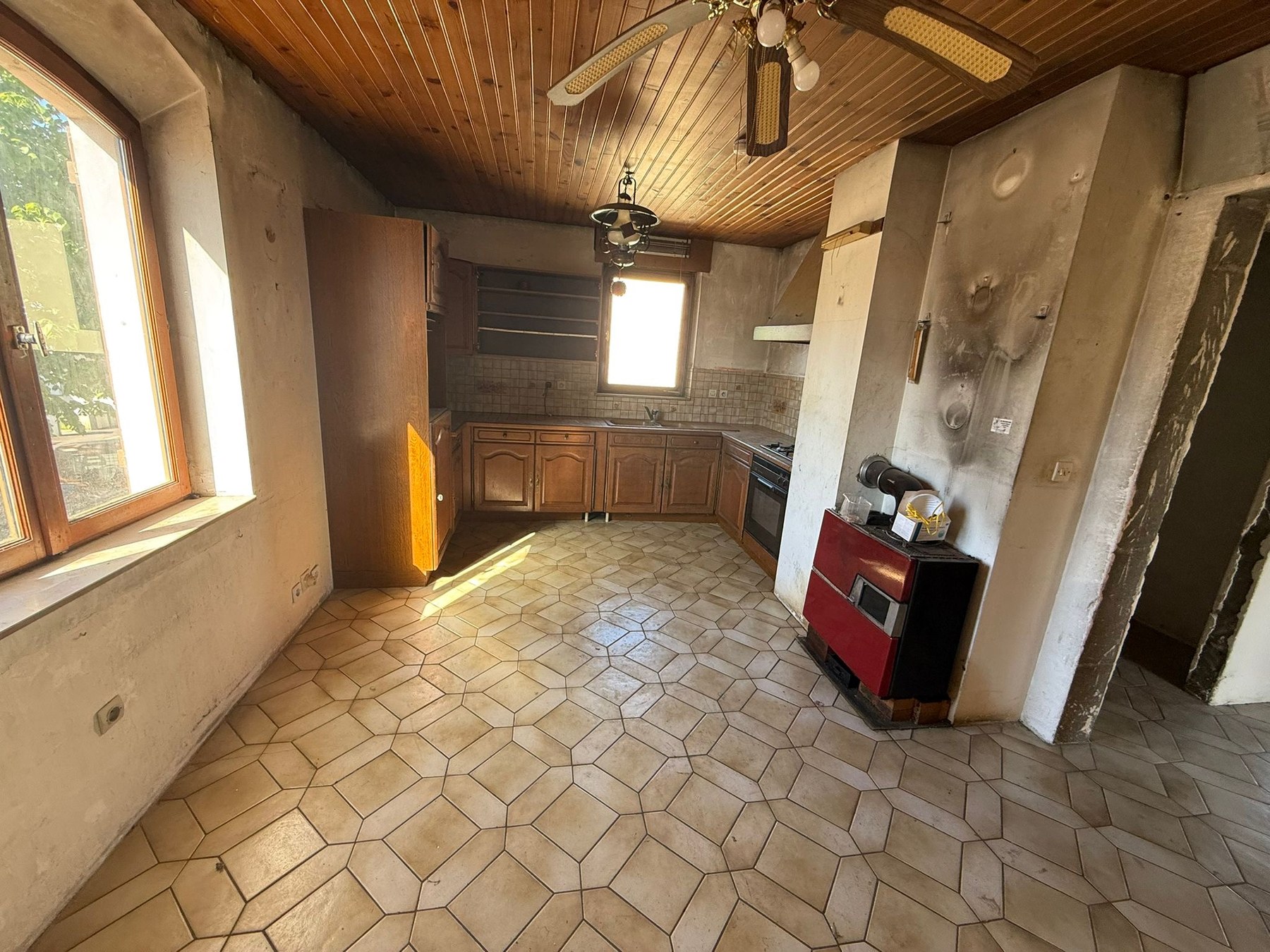 Cuisine d'origine très datée, plafond bois, équipements vieillissants