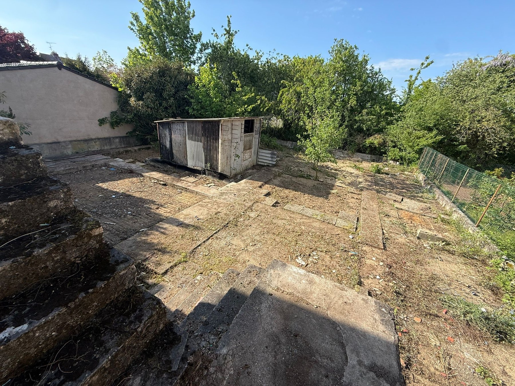 Jardin arrière clos mais à l'abandon, cabane métal à enlever