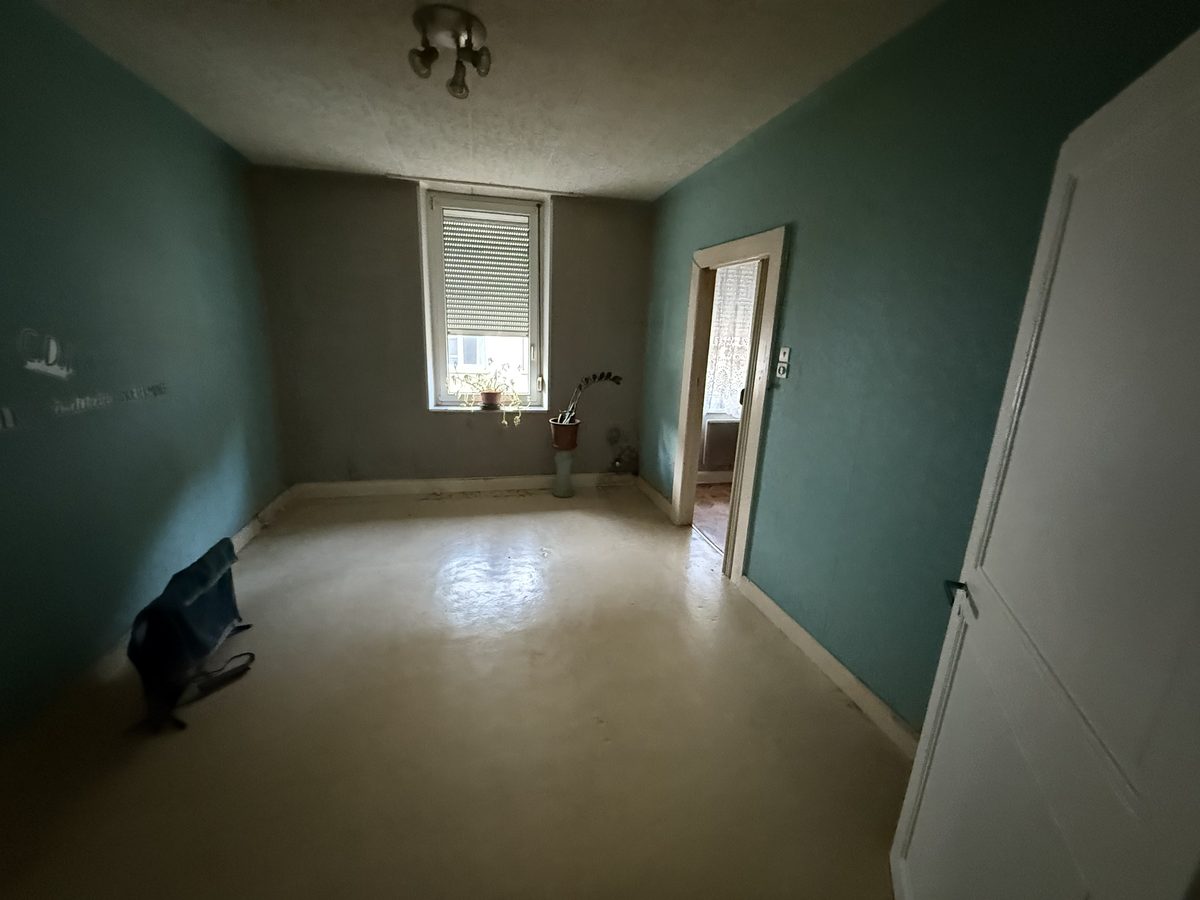 Chambre dans son état actuel, murs et sols à reprendre